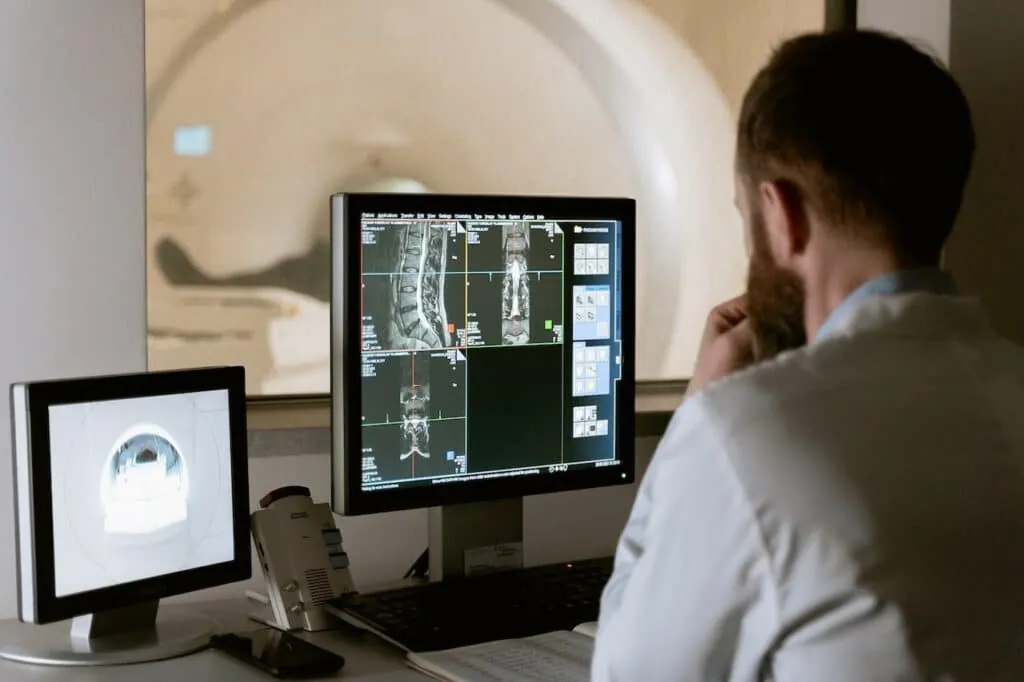 Radiologist reporting studies on screen connected to central PACS (teleradiology)